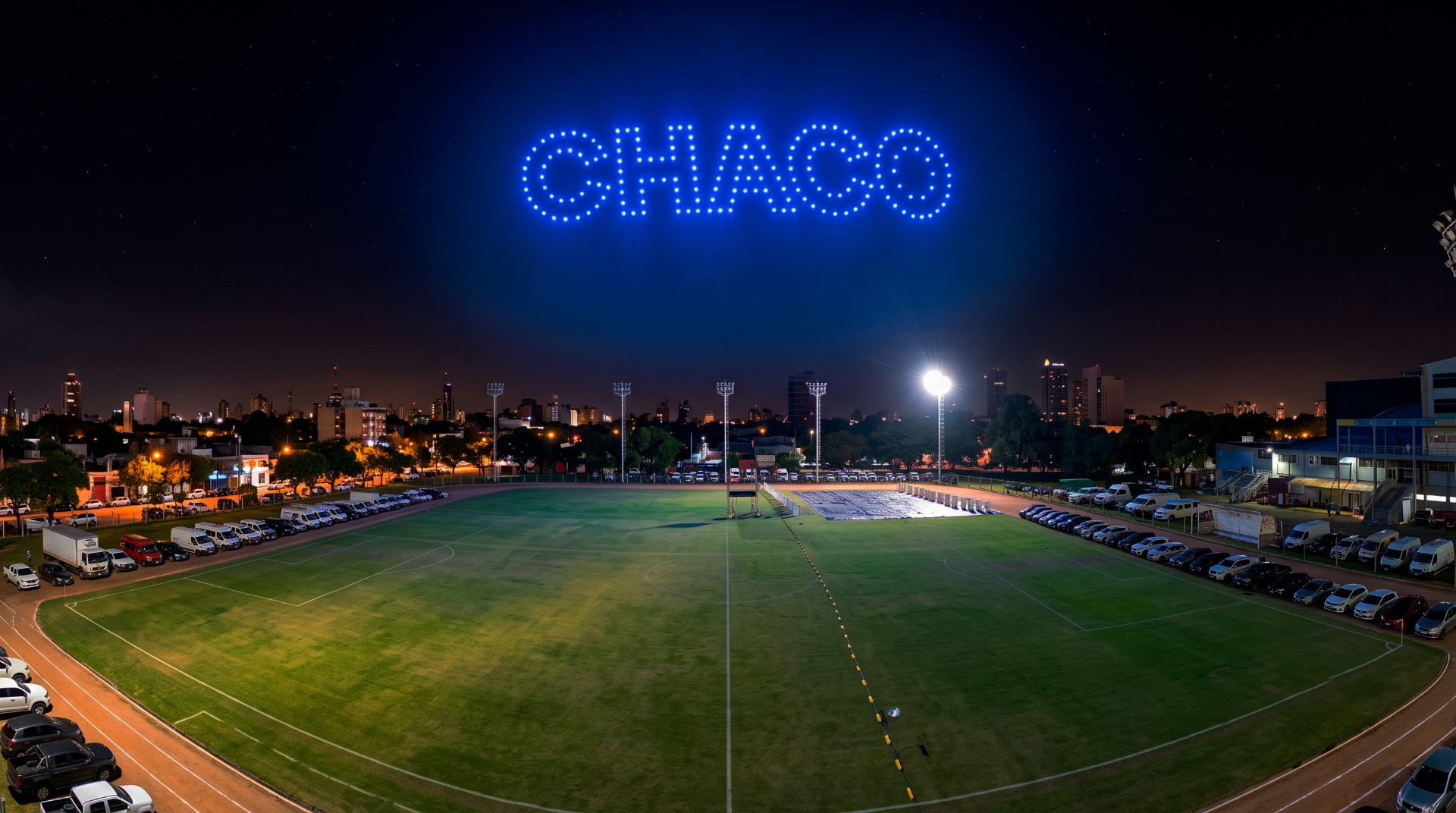 Palabra CHACO formada por drones azules sobre un campo deportivo de noche